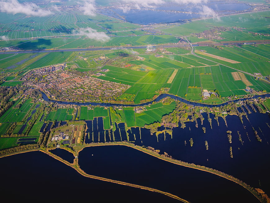 Aerial view of green farmland, river, and coastal water landscape