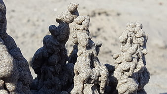 Close-up of intricate sand castle towers on a beach
