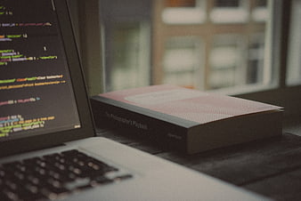 Laptop with code and photography book on desk