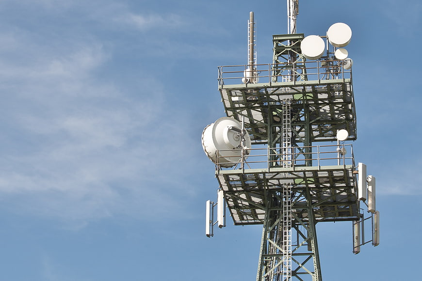 Telecommunications Tower With Satellite Dishes Against Blue Sky