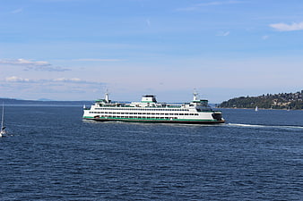 White and Green Ferry Boat Crossing Blue Water