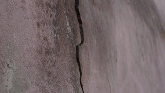 Close-up of cracked concrete wall texture with peeling paint
