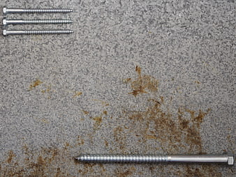 Metal screws on rusty industrial metal plate background