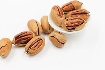 Cracked Pecans in Shells on White Background