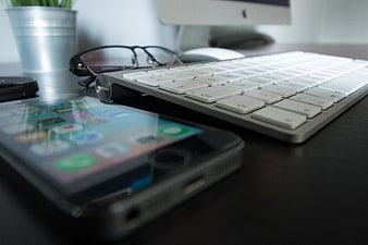 Modern Workspace with Smartphone, Keyboard, and Glasses