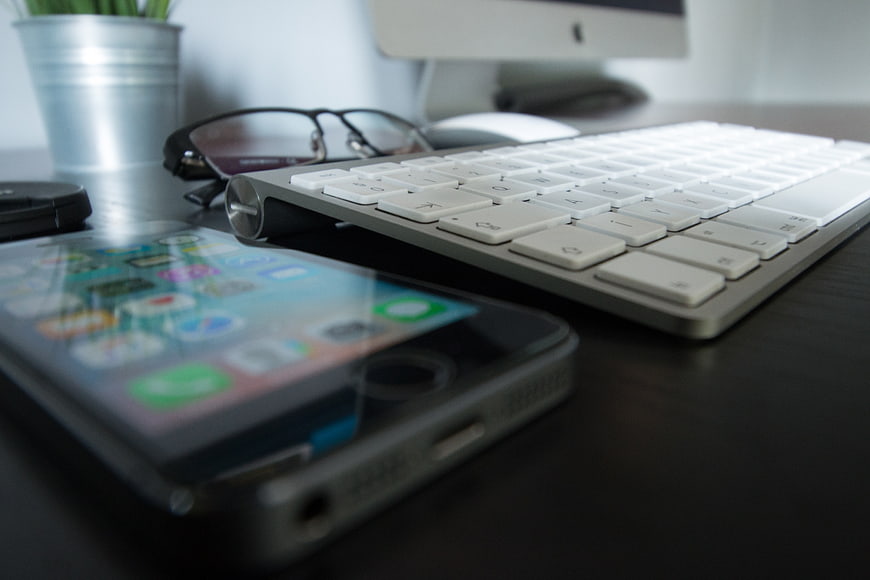 Modern Workspace with Smartphone, Keyboard, and Glasses