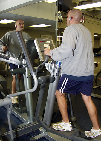 Man Exercising on Elliptical Machine in Gym