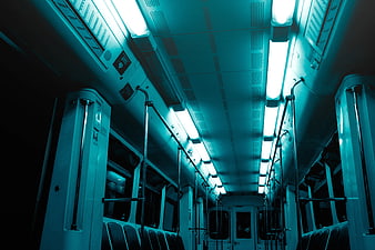 Empty subway car interior with cyan lighting and metal poles