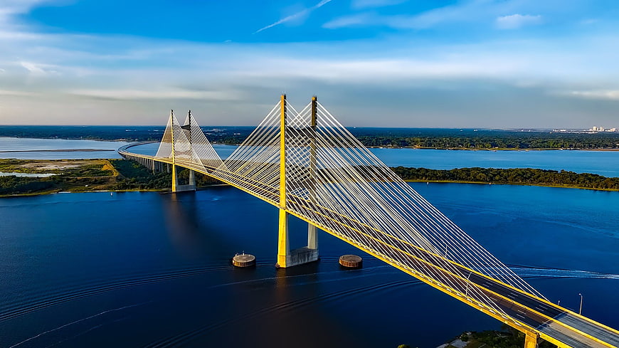 Aerial View of Yellow Cable-Stayed Bridge Over Blue Water
