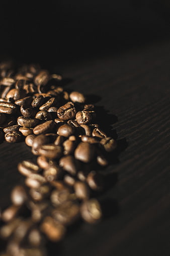 Close-up of roasted coffee beans on dark wood
