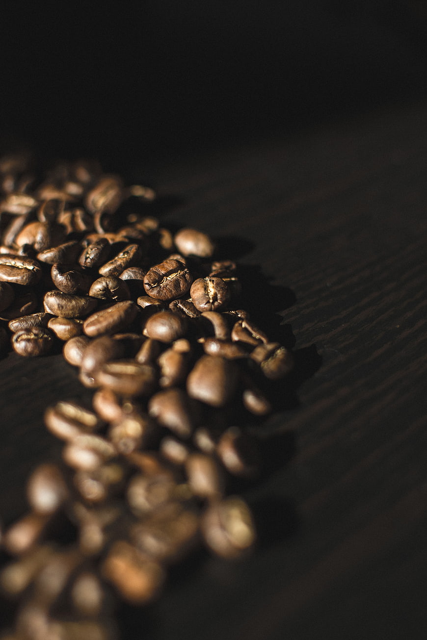 Close-up of roasted coffee beans on dark wood
