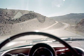 Vintage car dashboard view driving on winding desert highway