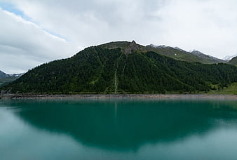 Serene Alpine Lake with Mountain Reflection and Waterfall