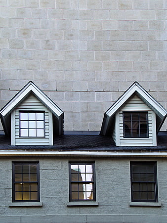 Modern gray stone building facade with dormer windows