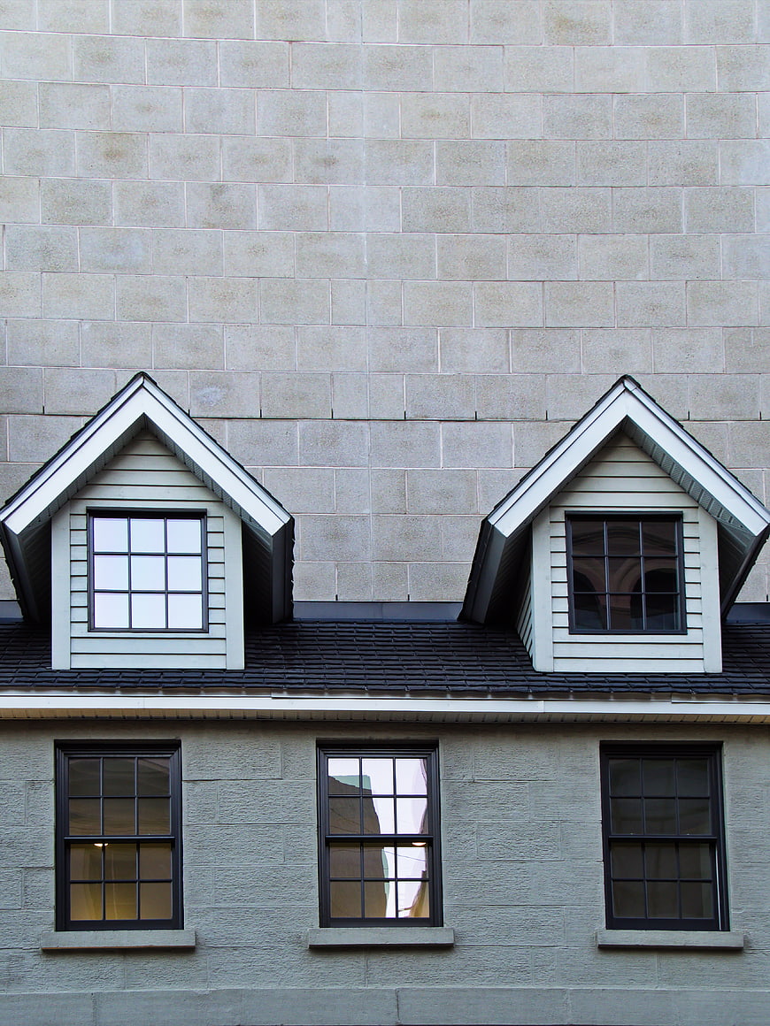 Modern gray stone building facade with dormer windows