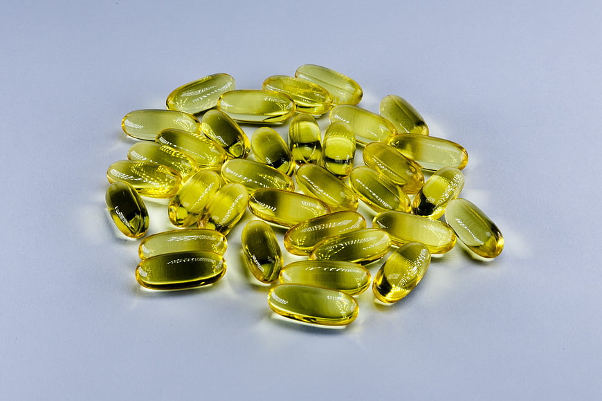 Yellow Softgel Capsules On Light Blue Background