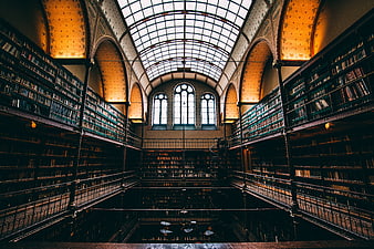 Grand historic library interior with glass ceiling and bookshelves