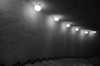 Black and white concrete staircase with row of spherical ceiling lights