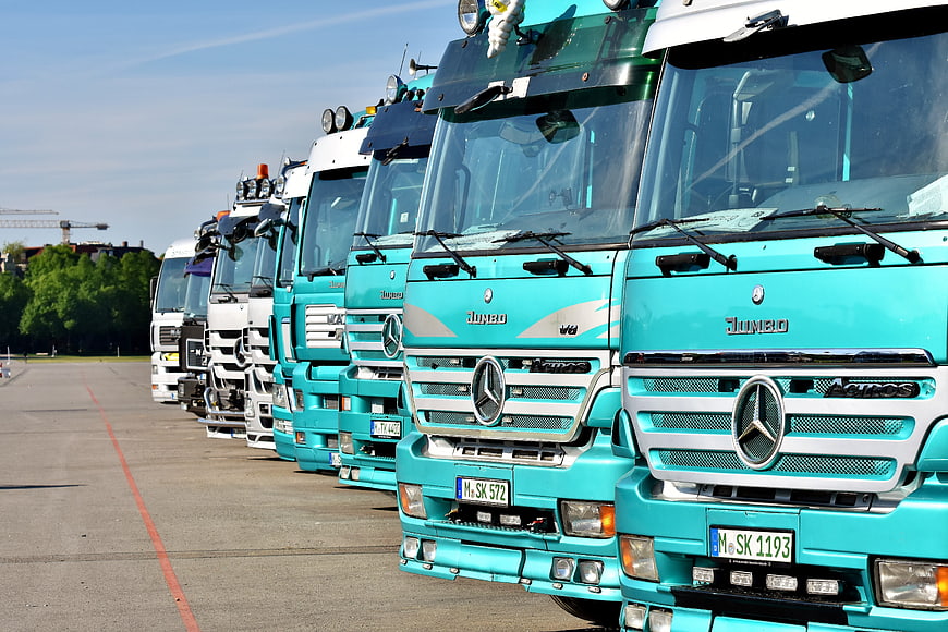 Row of Teal Mercedes-Benz Trucks Parked in a Yard