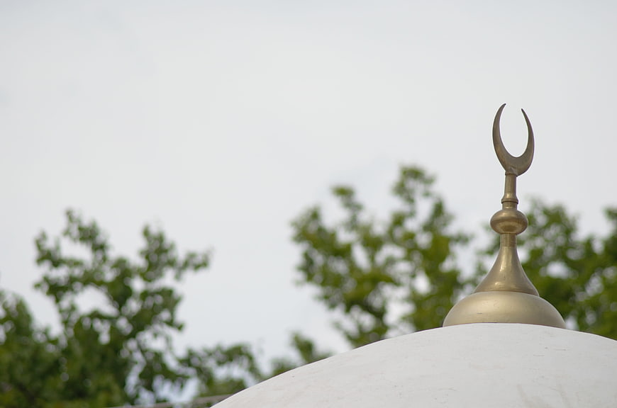 Islamic Crescent Finial On White Mosque Dome Against Overcast Sky