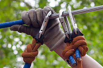 Gloved Hand Holding Carabiners on Steel Cable