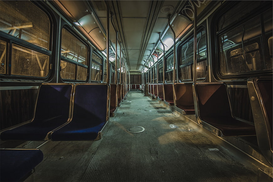 Empty subway car interior at night with blue seats