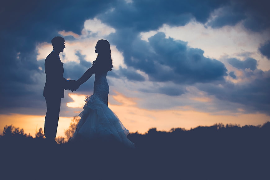 Silhouette of Bride and Groom Holding Hands at Sunset