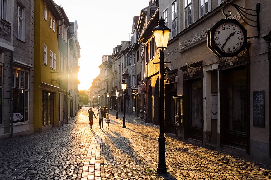 Family Walking on Cobblestone Street at Golden Hour