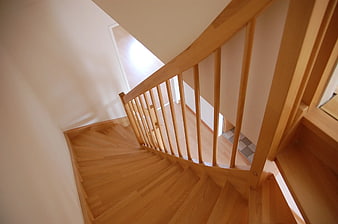 Curved wooden staircase with handrail in modern interior