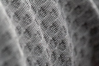 Close-up of gray knitted fabric texture with wavy pattern