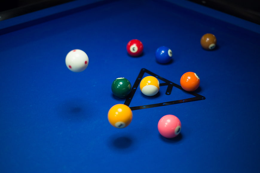 Colorful pool balls breaking on blue table