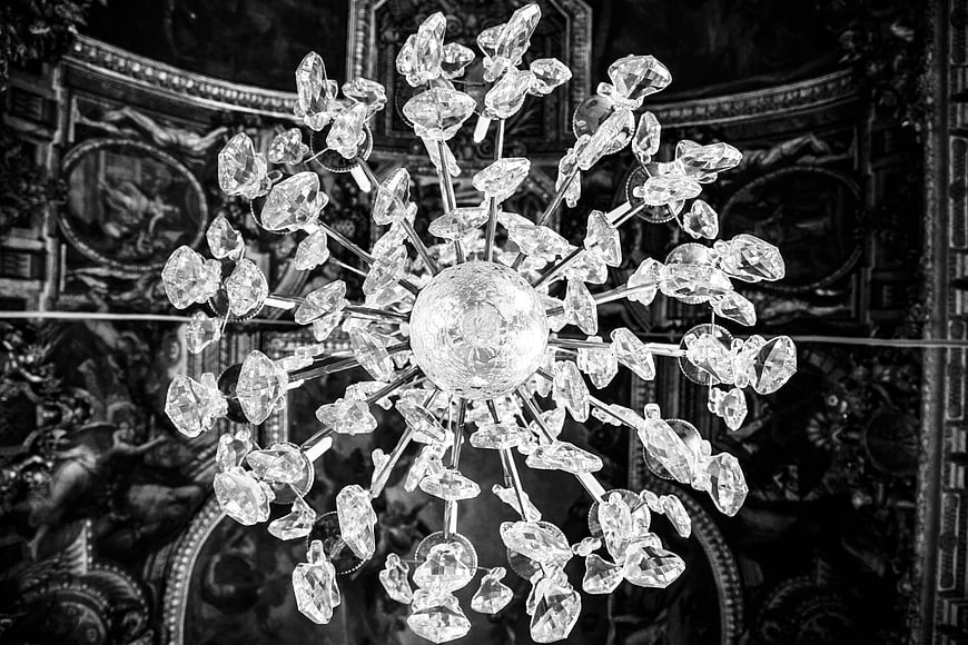 Black and white crystal chandelier hanging in ornate interior