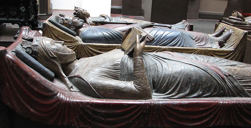 Medieval stone tomb effigies of royalty in church interior