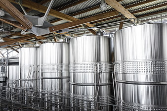 Stainless steel fermentation tanks in industrial winery interior