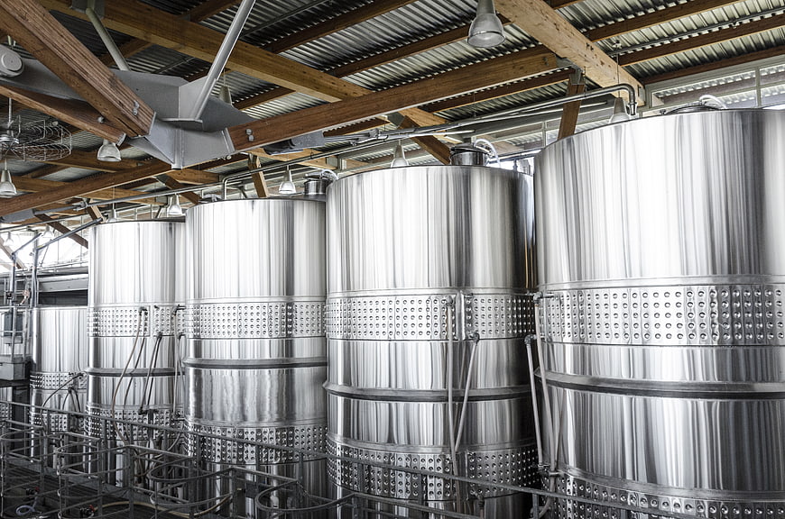 Stainless steel fermentation tanks in industrial winery interior