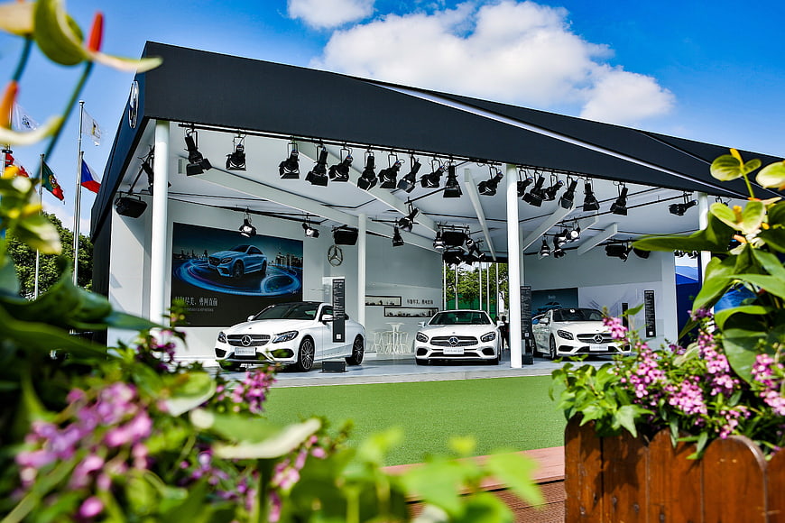 White Mercedes-Benz cars at outdoor exhibition with flowers