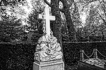 Black and white stone cross grave monument with chains
