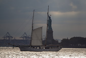 Sailboat passing Statue of Liberty in New York Harbor