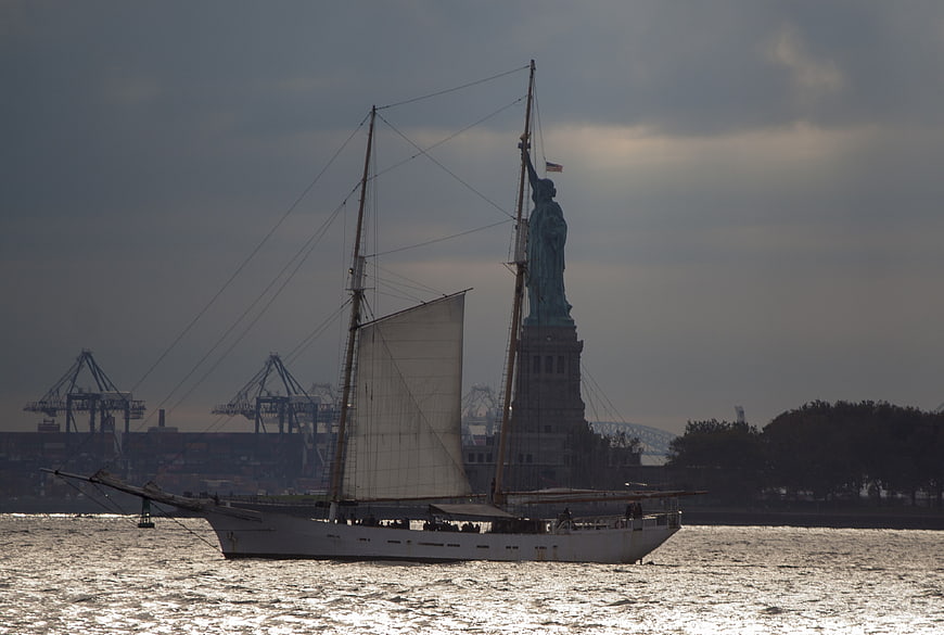 Sailboat passing Statue of Liberty in New York Harbor