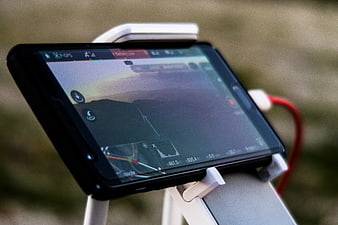 Smartphone mounted on drone controller displaying flight map