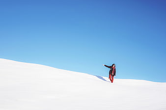 Woman in Red Walking on Snowy Mountain Slope