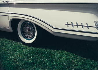 Close-up of vintage white car wheel on grass