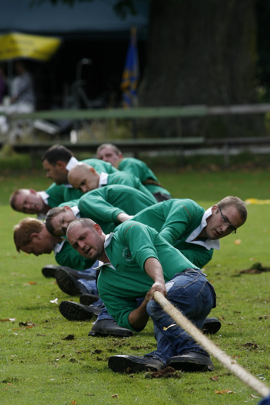 Men's Team Competing in Tug of War on Grass