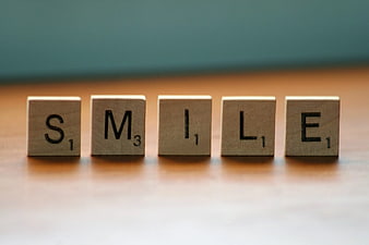 Wooden Scrabble Tiles Spelling Smile on Table