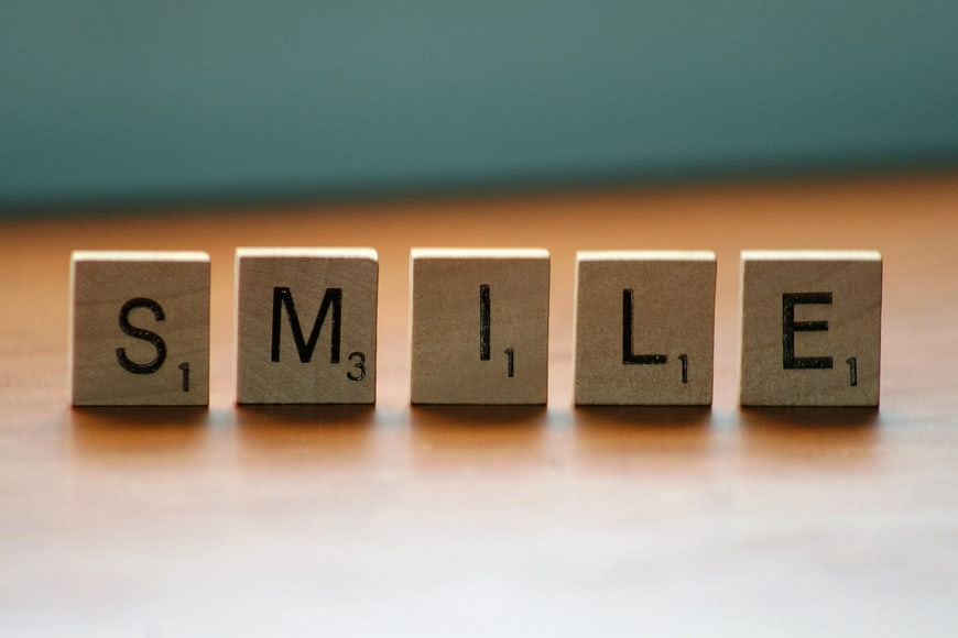 Wooden Scrabble Tiles Spelling Smile on Table