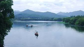Traditional Boats on West Lake with Distant Mountains