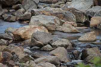 Flowing stream over large granite boulders in nature