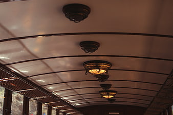 Vintage train carriage ceiling with warm lights and luggage racks