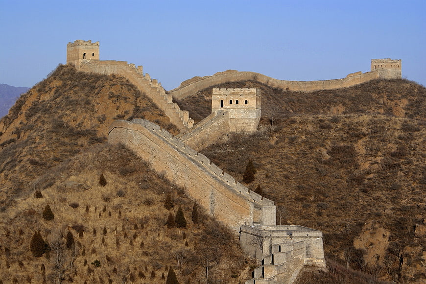 Great Wall of China winding through dry mountains