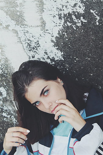 Portrait of Woman with Blue Eyes Against Textured Wall